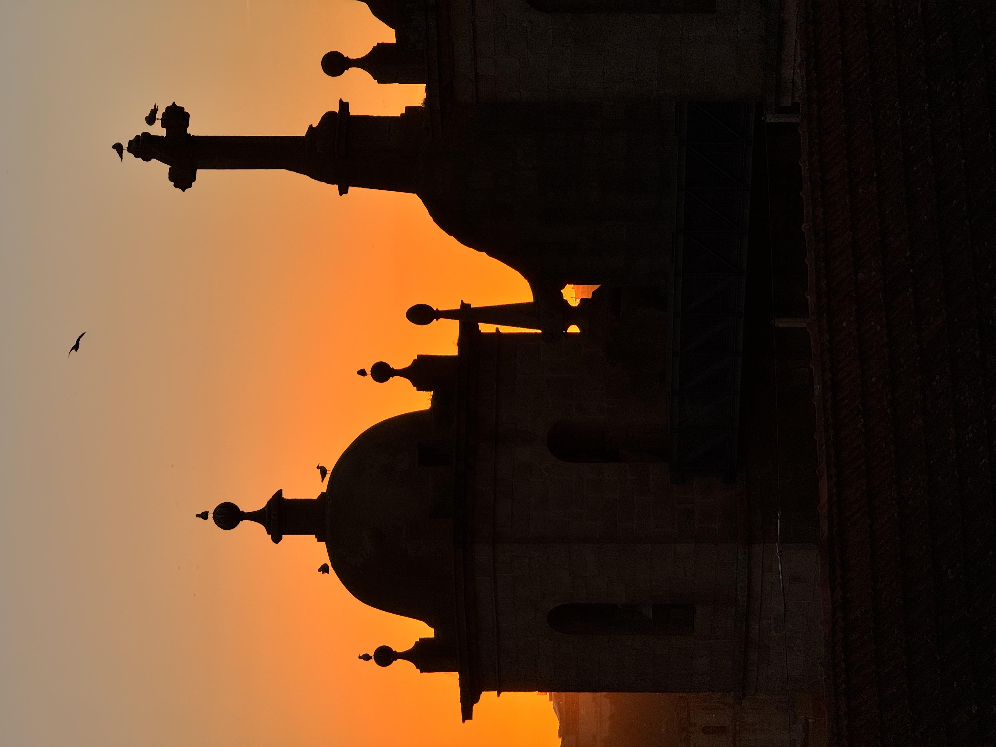Porto church silhouette against burnt orange sunset sky — Penelope Brair's hometown